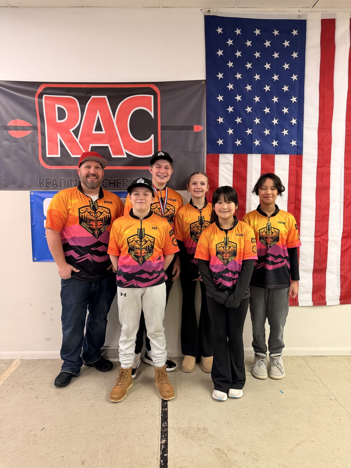 Five LPRGC archers and their coach in team jerseys at the Reading Archery Club indoor regional.
